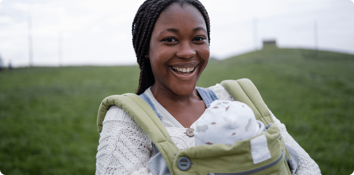 Woman smiling while carrying a baby